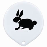 A white oval-shaped plastic accessory with a small hole at the bottom and a black rabbit silhouette printed in the center, shown on a plain white background.