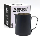 A black metal milk pitcher with a handle and pouring spout, shown in front of its white and black Rhino Classic Milk Pitcher box on a light gray background.