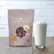 Sweetbird non-dairy vanilla bean product packaging with a glass of whipped cream on a wooden surface.